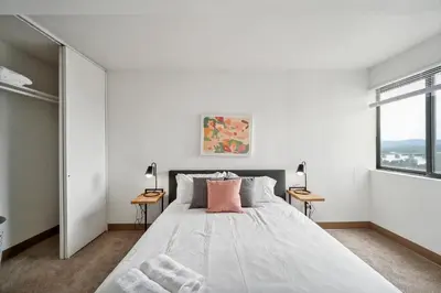 a white bedroom with a large bed and two windows at PP 1306 Modern Corporate 1br, pool, Gym in Harrisburg