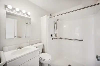 a white bathroom with a toilet and a sink at PP 1802 Modern Corporate 2br, pool, Gym in Harrisburg