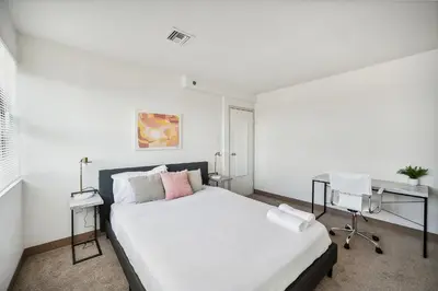 a bedroom with a large white bed and a desk at PP 1802 Modern Corporate 2br, pool, Gym in Harrisburg