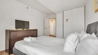 a bedroom with a bed with a dresser and a television at PP 1506 Beautiful Professional 1br Apt, Pool in Harrisburg