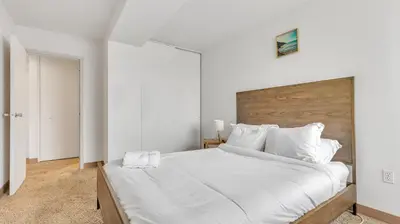 a bedroom with a large white bed with a wooden headboard at PP 1606 Beautiful Professional 1br Apt, Pool in Harrisburg