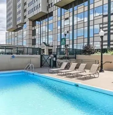 a swimming pool with lounge chairs and a building at PP 1606 Beautiful Professional 1br Apt, Pool in Harrisburg