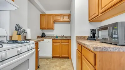 a kitchen with wooden cabinets and a microwave at PP 2006 Beautiful Professional 1br Apt, Pool in Harrisburg