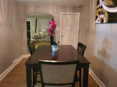a dining room table with a vase with a flower on it at Tranquility Room by the Airport -Shared space in Darby