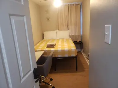 a room with a bed with a desk and a chair at Tranquility Room by the Airport -Shared space in Darby