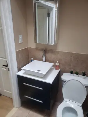 a bathroom with a white sink and a toilet at Tranquility Room by the Airport -Shared space in Darby