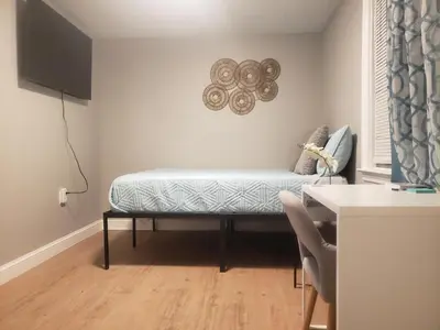 a bench in a room with a table and a television at Harmony Room with private bathroom by the Airport in Darby