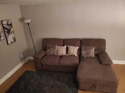 a brown couch in a living room with pillows on it at Harmony Room with private bathroom by the Airport in Darby