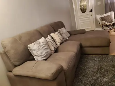 a brown couch with pillows on it in a living room at Harmony Room with private bathroom by the Airport in Darby