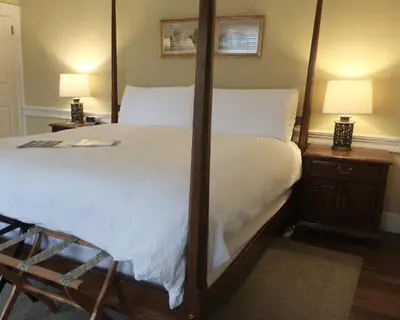 a bedroom with a four poster bed and two lamps at Inn at Glencairn in Princeton