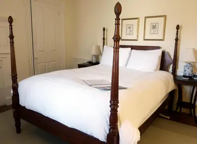 a bedroom with a large bed with white sheets at Inn at Glencairn in Princeton