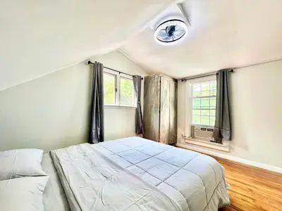 a bedroom with a bed and a clock on the wall at Town & Country Andover, NJ Area Apt- 2nd FL in Andover