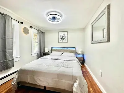 a bedroom with a large bed and two windows at Town & Country Andover, NJ Area Apt- 2nd FL in Andover