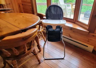 a high chair sitting next to a table at Secluded Mountain Lodge Near Williamsport with a Fireplace, Deck, and Pet-Friendly in Linden