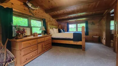a bedroom with a bed in a log cabin at Secluded Mountain Lodge Near Williamsport with a Fireplace, Deck, and Pet-Friendly in Linden