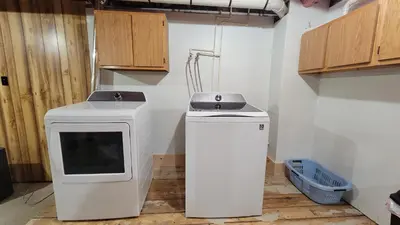 a kitchen with a stove and a dryer in a room at Secluded Mountain Lodge Near Williamsport with a Fireplace, Deck, and Pet-Friendly in Linden
