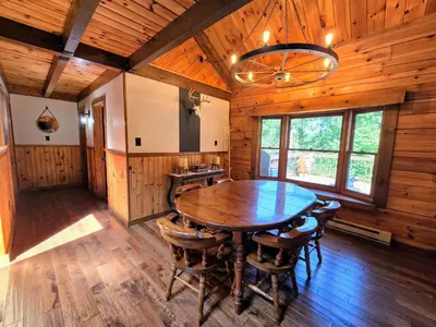 a dining room with a wooden table and chairs at Secluded Mountain Lodge Near Williamsport with a Fireplace, Deck, and Pet-Friendly in Linden