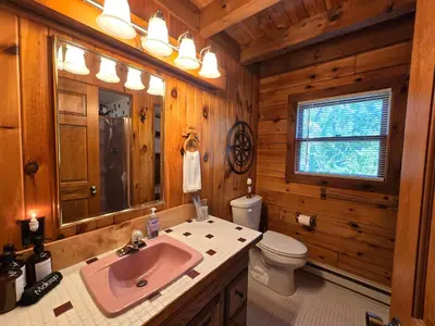 a bathroom with a sink and a toilet and a mirror at Secluded Mountain Lodge Near Williamsport with a Fireplace, Deck, and Pet-Friendly in Linden