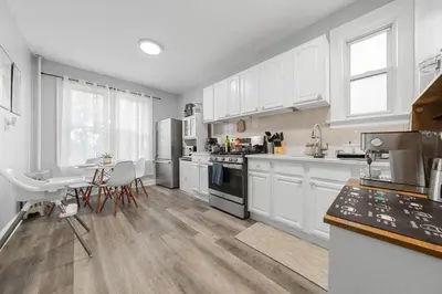 a kitchen with white cabinets and a table and chairs at 