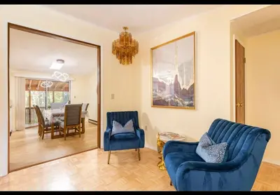 a living room with two blue chairs and a dining room at The Escape in Albrightsville