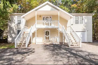 a white house with stairs leading up to it at The Escape in Albrightsville