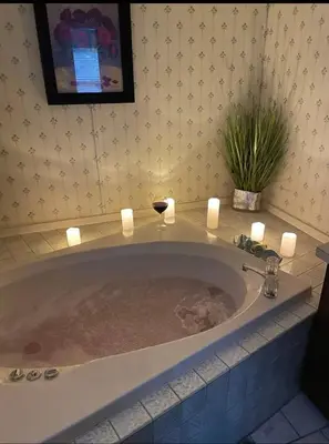 a bath tub with candles and a glass of wine in it at The Escape in Albrightsville