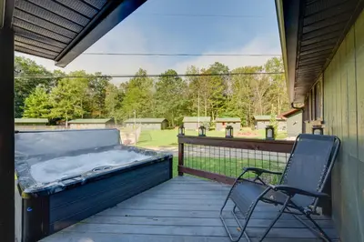 a porch with a bed and a chair on a deck at Private Hot Tub Main Cabin at Elk Creek Escape! in Hillsgrove