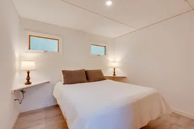 a white bedroom with a bed and two windows at Community Perks Elk Creek Escape - Deluxe Cabin C in Hillsgrove