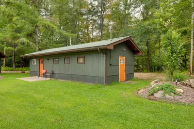 a green building with orange doors in a yard at Community Perks Elk Creek Escape - Deluxe Cabin C in Hillsgrove