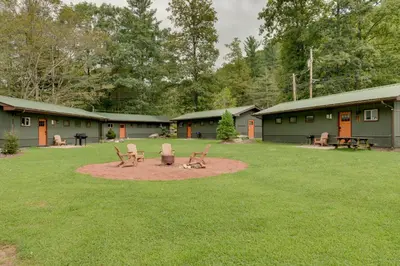 a yard with two chairs and a picnic table at Community Perks Elk Creek Escape - Deluxe Cabin C in Hillsgrove