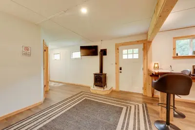 a living room with a chair and a fireplace at Shared Perks Deluxe Cabin B at Elk Creek Escape! in Hillsgrove