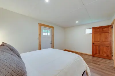 a bedroom with a white bed and a wooden door at Shared Perks Deluxe Cabin B at Elk Creek Escape! in Hillsgrove