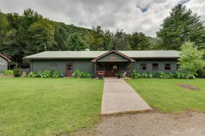 a green building with a sidewalk in front of a yard at Shared Perks Deluxe Cabin B at Elk Creek Escape! in Hillsgrove