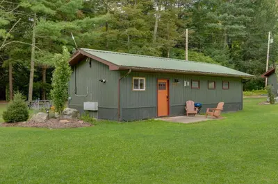 a green shed with an orange door in a yard at Deluxe Cabin A at Elk Creek Escape Pet Friendly! in Hillsgrove
