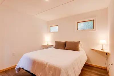 a bedroom with a white bed and two windows at Deluxe Cabin A at Elk Creek Escape Pet Friendly! in Hillsgrove