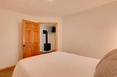 a bedroom with a bed and a stove in it at Deluxe Cabin A at Elk Creek Escape Pet Friendly! in Hillsgrove