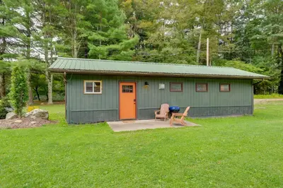 a green shed with an orange door and a bench at Deluxe Cabin A at Elk Creek Escape Pet Friendly! in Hillsgrove