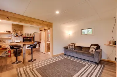 a living room with a couch and a kitchen at Deluxe Cabin A at Elk Creek Escape Pet Friendly! in Hillsgrove