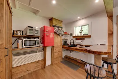 a kitchen with a red refrigerator and a table at 9 Mi to Worlds End State Park Deluxe Cabin H in Hillsgrove