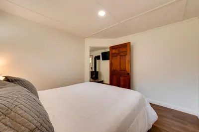 a bedroom with a white bed and a wooden cabinet at 9 Mi to Worlds End State Park Deluxe Cabin H in Hillsgrove