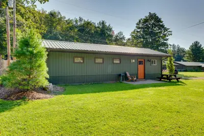a green house with a picnic table and a bench at 9 Mi to Worlds End State Park Deluxe Cabin H in Hillsgrove