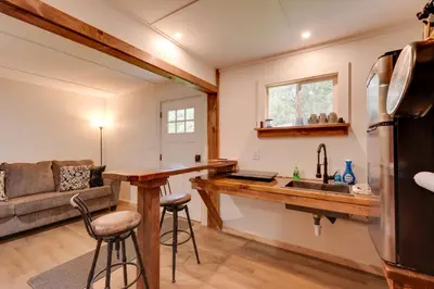 a kitchen and living room with a sink and a couch at Deluxe Cabin G 9 Mi to Worlds End State Park! in Hillsgrove