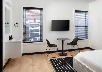 a bedroom with a bed and two chairs and a table at Kasa The Niche University City Philadelphia in Philadelphia