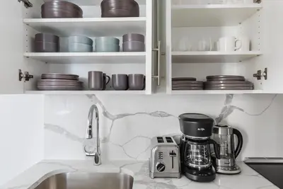 a kitchen counter with a coffee maker and cups at Blueground Midtown gym elev nr Grand Central NYC-1479 in New York