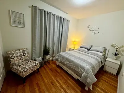 a bedroom with a bed and a chair at Private 1st floor Apartment - Only 5 min Away from Newark Airport and 30 min to NYC in Elizabeth