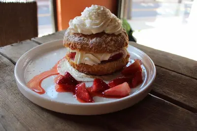 a pastry on a plate with strawberries on a table at Cottage Suites in Middletown