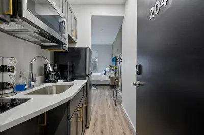 a kitchen with a sink and a black door at Cottage Suites in Middletown
