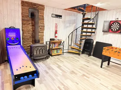 a room with a video game system in front of a fireplace at Bethel Escape Hot Tub 4 beds Game Room and Fire pit Fully Stocked Kitchen in Smallwood