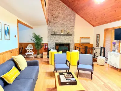 a living room with a blue couch and yellow chairs at Bethel Escape Hot Tub 4 beds Game Room and Fire pit Fully Stocked Kitchen in Smallwood
