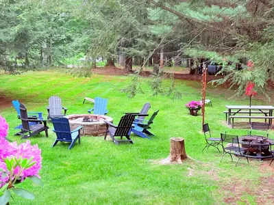 a group of chairs and tables in a yard at Bethel Escape Hot Tub 4 beds Game Room and Fire pit Fully Stocked Kitchen in Smallwood